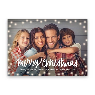 Christmas Cards: A holiday photo card of a family of four framed by string lights with the text merry christmas and Love, Michelle, Brendan, Olivia & Jamie Sinclaire.