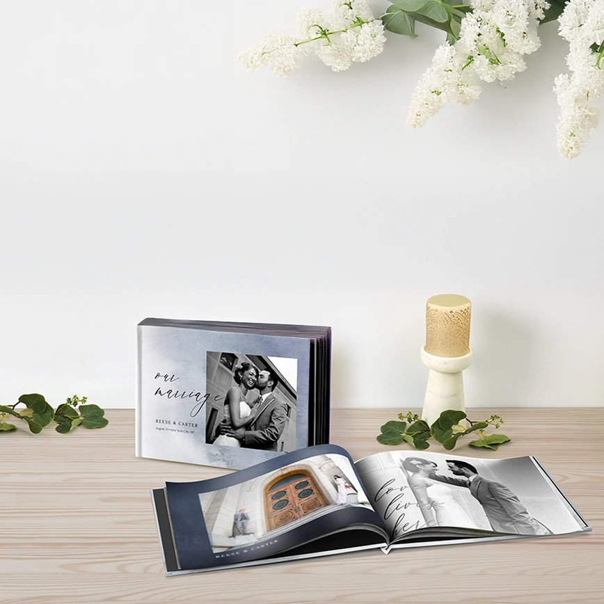 Shop all Photo Books: A closed wedding photo book next to an open copy showing an inside page spread with more photos.