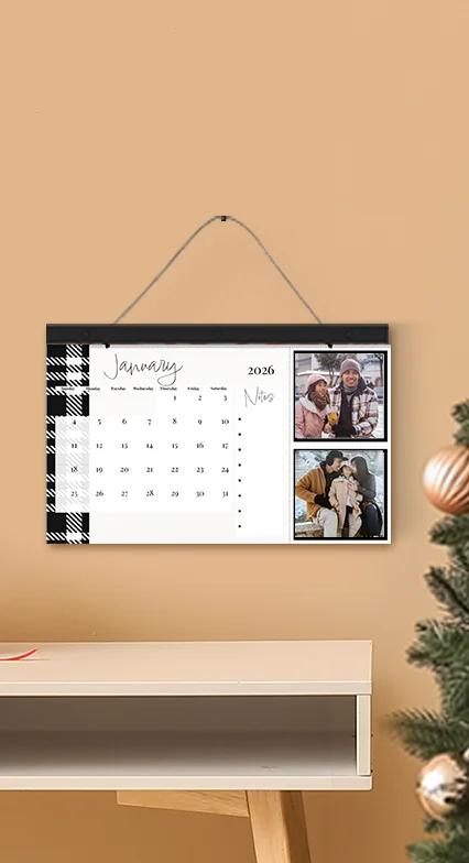 Custom Wall Calendars: A personalized wall keepsake calendar with a black and white plaid border, showing two square photos of a couple next to the month of January 2026.