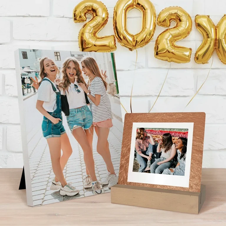 Gifts for her: A personalized canvas print and a desktop photo print displayed on a desk with celebratory balloons.