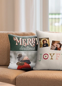 Custom Pillows: Two custom photo throw pillows resting on a tan couch; one is green with the text MERRY christmas and a photo of a child, the other is white with two photos and the text JOYFUL.